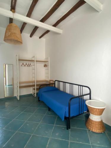a bedroom with a bed and a ceiling with beams at Pensione La Nassa in Stromboli