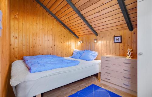 a bed in a room with a wooden wall at Holiday Home Nordbakken Havndal Xii in Sødring