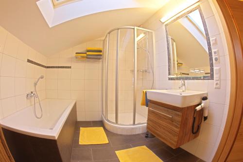 ein Badezimmer mit einem Waschbecken, einer Badewanne und einer Dusche in der Unterkunft Familien-Bauernhof Neumoar in St. Johann im Pongau
