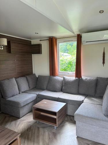 a living room with a couch and a table at Camping du Château Vert in Hondainville