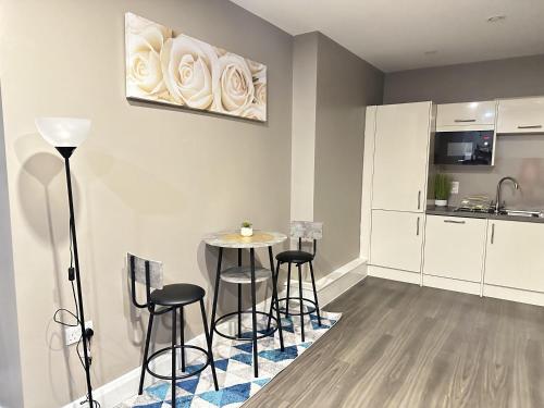 a kitchen with a table and stools in a room at 2 Bed Apartment - Sleeps 4 - Wifi - Parking in Dudley