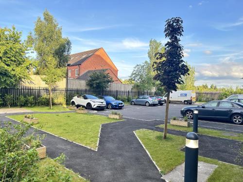 a parking lot with cars parked in front of a house at 2 Bed Apartment - Sleeps 4 - Wifi - Parking in Dudley