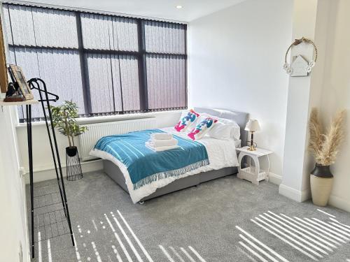 a bedroom with a bed and a large window at 2 Bed Apartment - Sleeps 4 - Wifi - Parking in Dudley