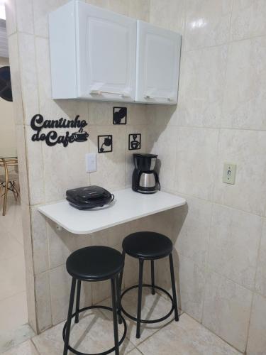 a counter with two black stools in a kitchen at Casa aconchegante no Centro da Cidade - Cantinho da Bia MP in Miguel Pereira