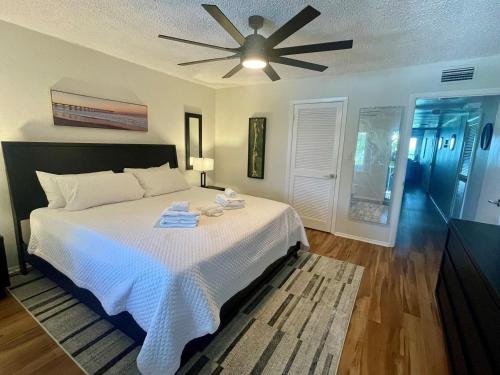 a bedroom with a bed with a ceiling fan at 7th Heaven condo in Longboat Key