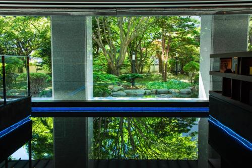 a reflection of a garden in a pool in a house at Bourou Noguchi Hakodate in Hakodate