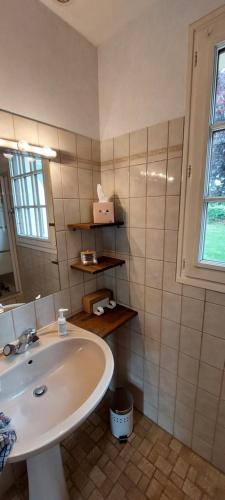 une salle de bain avec un lavabo blanc et une fenêtre dans l'établissement Ô Ptits KER - 6 à 8 personnes A proximité de la mer, à Quettehou