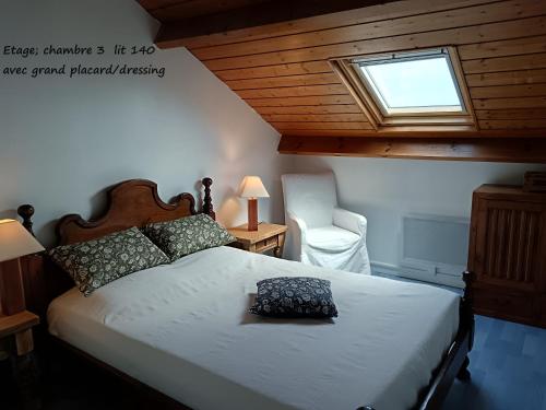 une chambre avec un lit, une fenêtre et une chaise dans l'établissement Duplex face Mer au pied des plages exceptionnelle vue mer, à Arzon