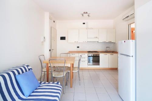 a kitchen and dining room with a table and chairs at APPARTAMENTO MARCONI B2 in Lido di Jesolo