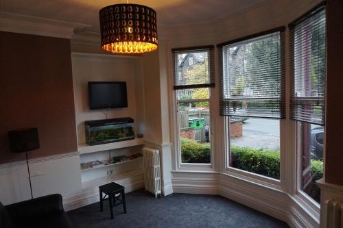 a living room with two large windows and a chandelier at The Butlers Hotel in Leeds