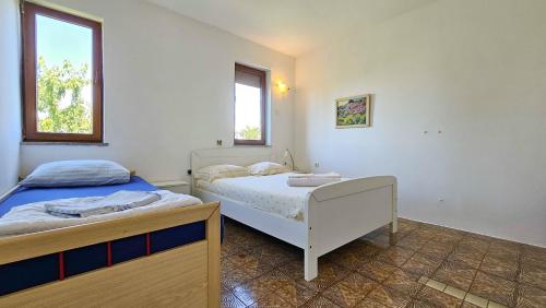 ein Schlafzimmer mit zwei Betten und zwei Fenstern in der Unterkunft Davor 1 in Dajla