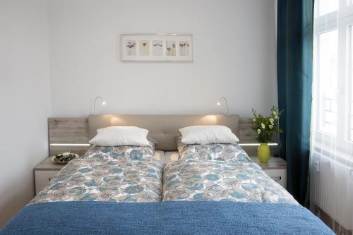 a bedroom with two beds with blue sheets at Leon Suite Apartments in Leipzig