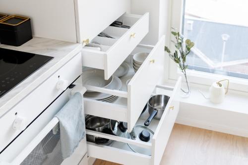 a kitchen with white cabinets and open drawers at Best location, cozy and peaceful in Tampere