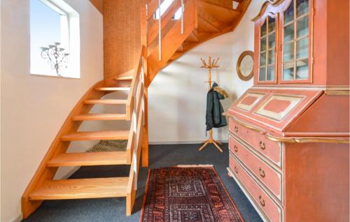 a wooden staircase in a room with a dresser at 4 Bedroom Lovely Home In Bandholm in Bandholm