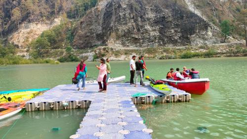 a group of people standing on a dock in the water at Hotel HBH Himalaya's Beautiful Hills in Uttarkāshi