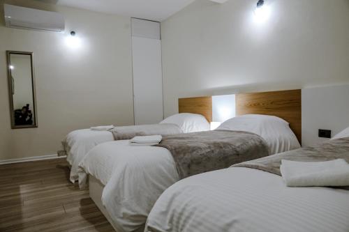 a group of four beds in a room at Vila Pllaha in Korçë