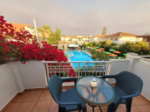 a balcony with a table and chairs and a pool at HELEN STUDIOS in Plános