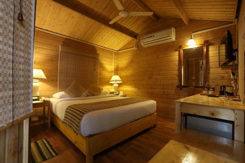 a bedroom with a bed in a wooden room at Lotus an Eco Resort Konark in Konārka