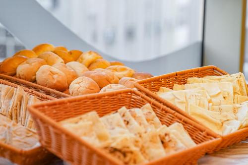 two baskets filled with different types of bread and pastries at Emaar Elite Hotel in Makkah