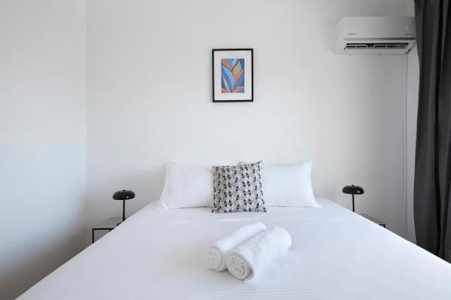 a bedroom with a white bed with two towels on it at Urban Condo 11 - 1 Bdr in Nicosia