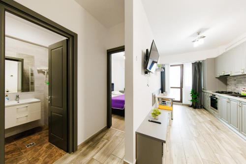 a kitchen and a living room with a door to a bathroom at DEKO Apartments & Studios Near Palas Mall in Iaşi