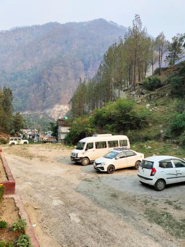 a group of three cars parked on a dirt road at Hotel HBH Himalaya's Beautiful Hills in Uttarkāshi