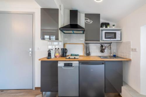 une cuisine avec des appareils en acier inoxydable et un comptoir en bois dans l'établissement Villa Anaite Piscine privée, à Antibes