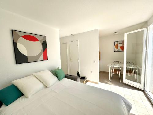 une chambre avec un grand lit blanc dans une pièce dans l'établissement Beach Cannes Bungalows, au Cannet