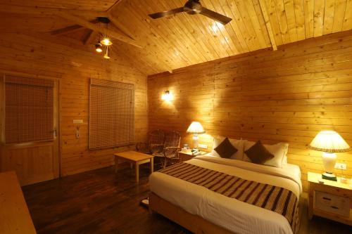 a bedroom with a bed in a wooden room at Lotus an Eco Resort Konark in Konārka