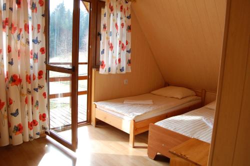 レスコにあるChaty Lesko-Skiのベッド2台と窓が備わる小さな客室です。