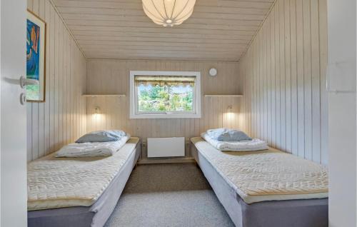 two beds in a small room with a window at Holiday Home Filosofstræde Dannemare V in Dannemare