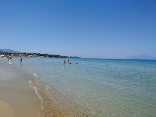 a group of people in the water at the beach at HELEN STUDIOS in Plános