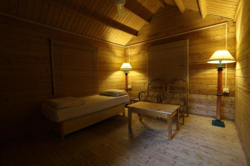 a room with a bed and a table and two lamps at Lotus an Eco Resort Konark in Konārka