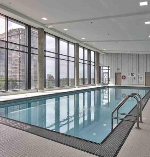 a large swimming pool in a building with windows at Modern spacious Apt plus Solarium and Den in Downtown Vancouver with Parking and Pool in Vancouver