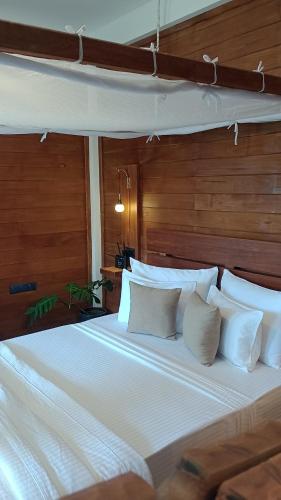 a bedroom with a large bed with white pillows at Lush In Ella in Ella