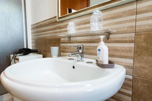 a bathroom sink with a bottle of soap on it at B&B Profumi di Sicilia in Valderice
