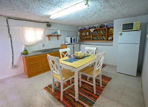 a kitchen with a table and chairs and a white refrigerator at Poppy's House in Emborios Kalymnos