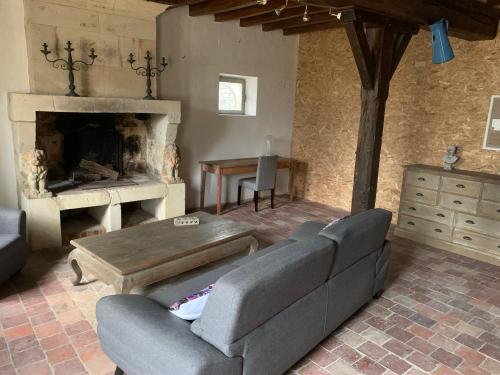 un salon avec un canapé et une cheminée dans l'établissement La frelonniere, à Pontlevoy