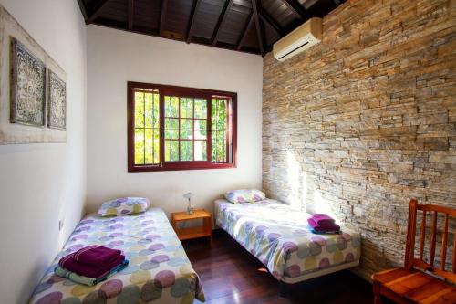 a bedroom with two beds and a brick wall at Villa Jardín de Buda in Arona