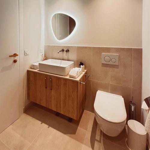 a bathroom with a white toilet and a sink at VILLTAK SAINT-TROPEZ by VILLTAK Collection in Saint-Tropez
