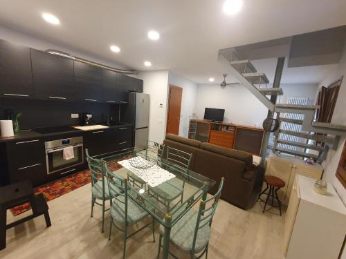 a living room with a glass table and a kitchen at Appartamenti vicino al lago con bikeparking in Verbania