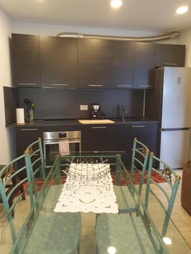 a kitchen with a table with chairs and a refrigerator at Appartamenti vicino al lago con bikeparking in Verbania