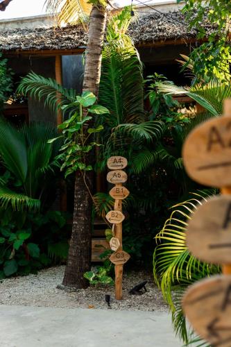 a group of signs in front of a tree at The Garten Living in Paje
