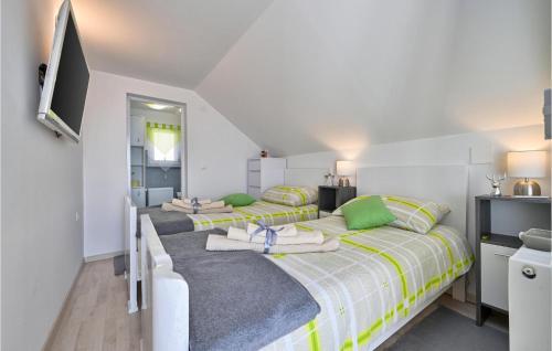 a group of four beds in a room at Cozy Home In Martinkovec With Wifi in Varaždinske Toplice