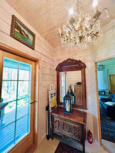 a room with a table and a mirror and a chandelier at Villa Viena in Ähtäri