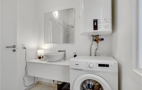 a white bathroom with a washing machine and a sink at Nice Home In Vordingborg With Wifi in Vordingborg