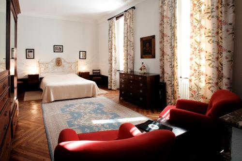 a bedroom with a bed and a couch and chairs at Vila Duparchy in Luso