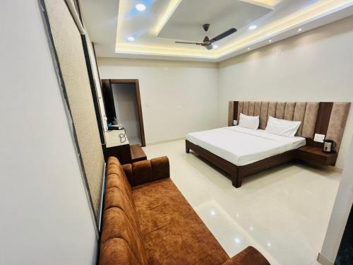 a bedroom with a bed and a couch in it at Hotel Hallmark By THC Group in Kota