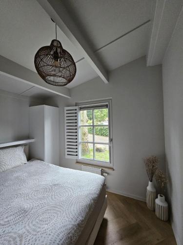 a bedroom with a white bed and a window at Casa do Cervo, Boshof 6 Luxe met overdekt terras in Ermelo