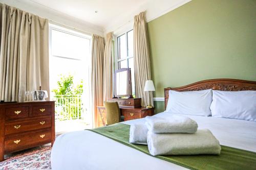 1 dormitorio con 1 cama, vestidor y ventana en The Wellington, en Ventnor